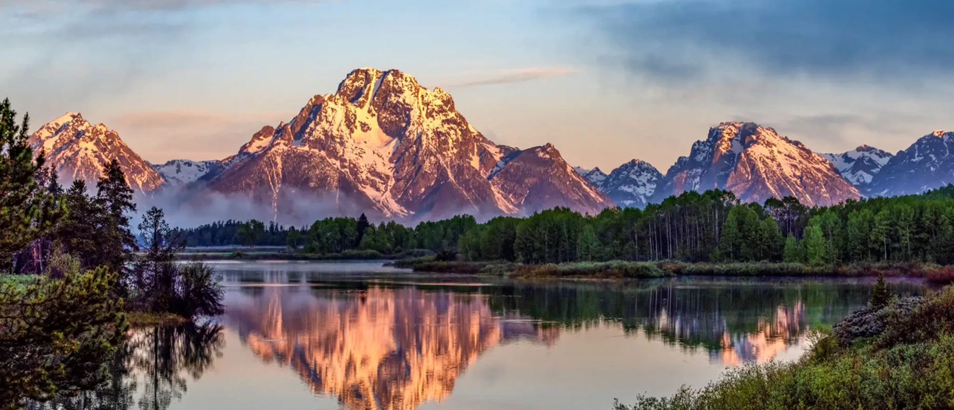 Snowy mountains reflecting in a calm lake.