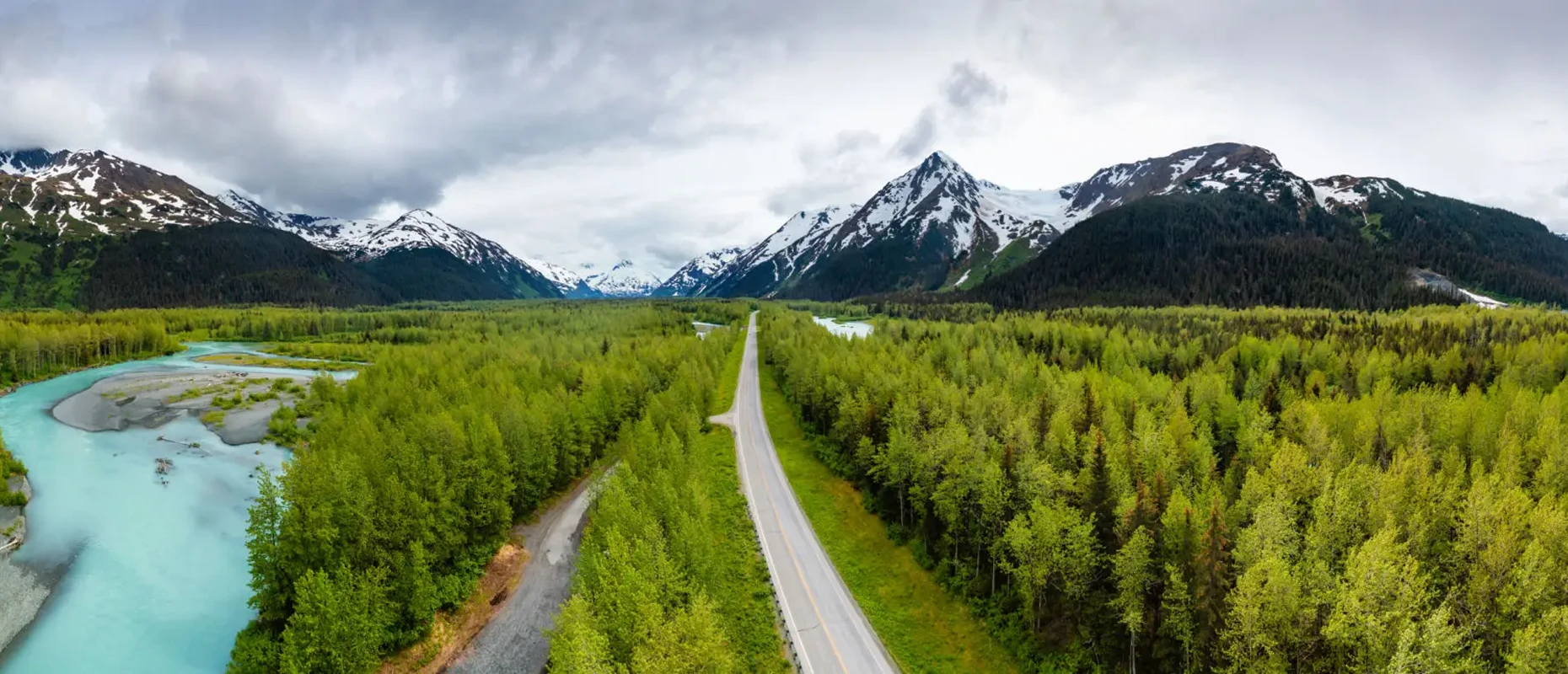 Scenic road through forest and mountains.