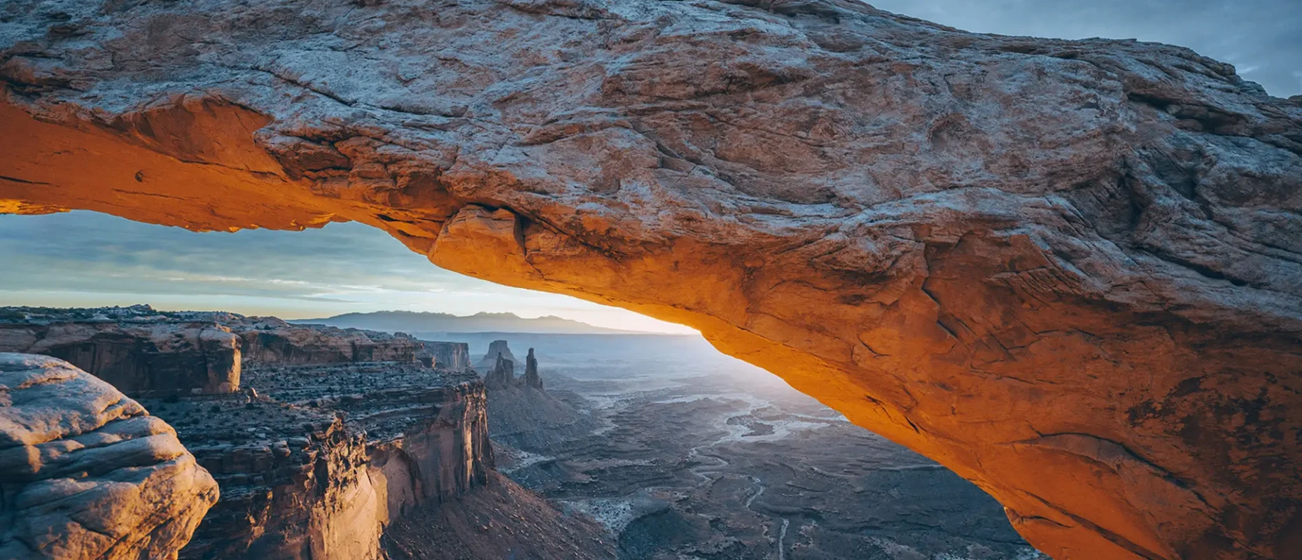 Sunrise view through natural rock arch.